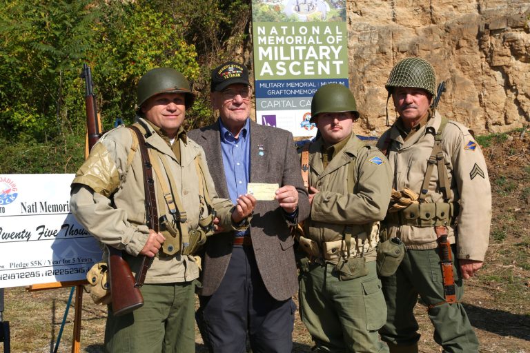 Grafton Mayor Mike Morrow accepting a donation from the reenactment soldiers at the future site of The National Memorial of Military Ascent